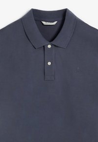 Polo bleu marine en coton texturé, doté d'un col classique, d'une patte de boutonnage à trois boutons et d'un logo discret brodé sur la poitrine.