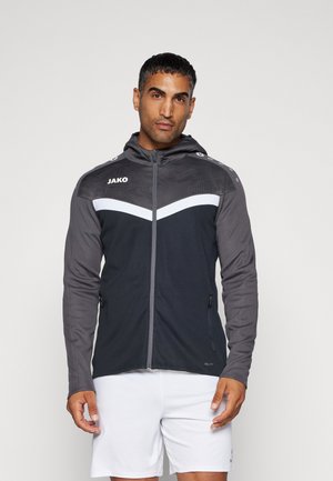 Dunkelgraue Jacke mit Kapuze, durchgehendem Reißverschluss und weißem Chevronmuster. Hergestellt aus strukturiertem Stoff mit zwei seitlichen Reißverschlusstaschen.