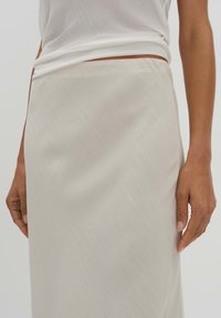 Helles beige, glattes Stoffrock mit einer subtilen Textur, knielang, mit einem enganliegenden Bund und gerade geschnittenem Design.