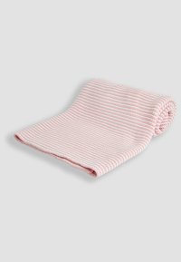 Morbida coperta lavorata a maglia a strisce rosa chiaro e bianco, parzialmente arrotolata su uno sfondo grigio chiaro uniforme.