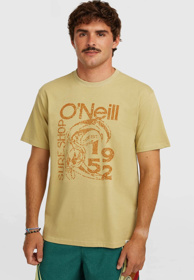 Μπεζ βαμβακερό t-shirt με πορτοκαλί γραφικό τύπωμα και κείμενο "O'Neill Surf Shop EST 1952." Κλασικός στρογγυλός λαιμός και κοντά μανίκια.