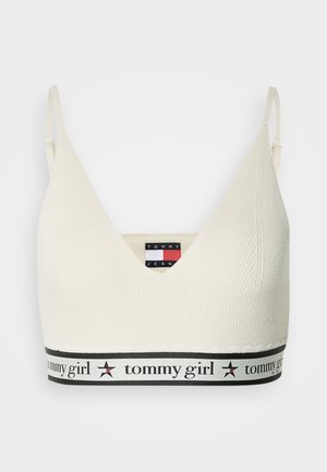 Cremfarbener, gestrickter Bralette mit verstellbaren Trägern, tiefem V-Ausschnitt und schwarzem Bund mit dem Schriftzug "tommy girl" und Stern-Icons.