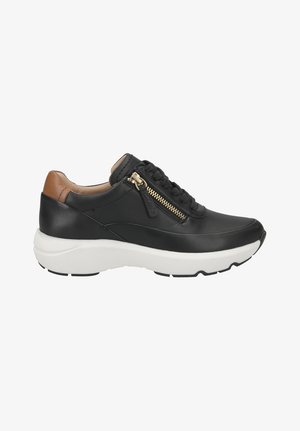 Zwarte leren sneaker met een witte zool, voorzien van een zijrits en bruine leren accenten op de hak, gestructureerde veters, modern ontwerp.