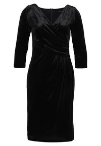 Svart sammetsklänning med V-ringning, trekvartsärmar och drapering vid midjan. Slät textur och knälängd. Dragkedja bak.
