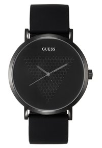 Ceas cu brățară din silicon negru, cu un cadran rotund de culoare neagră ce prezintă un model triunghiular de fagure, ace pentru ore și minute din argint și numele brandului "GUESS."