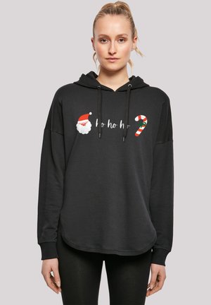 Black hoodie with loose fit, featuring a hood and drawstrings. Front design includes "ho ho ho," Santa face, and a candy cane accent.