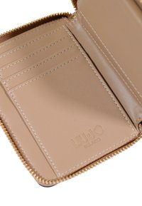 Interiér béžové kožené peněženky s šesti přihrádkami na karty, hladkou texturou, zlatým zipem a raženým logem "LIU·JO MILANO".