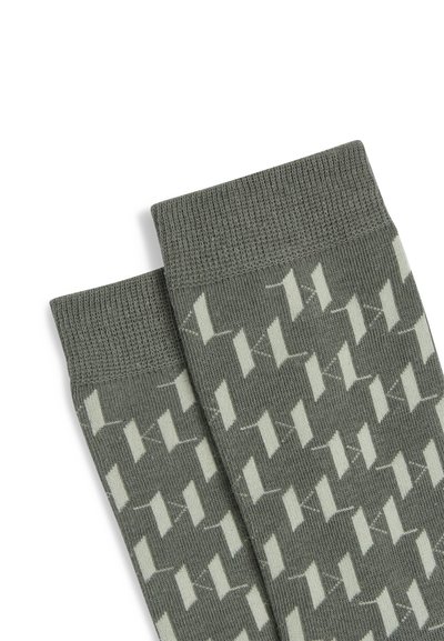 Paire de chaussettes grises avec motif pied-de-poule géométrique blanc, avec des bords-côtes en haut.