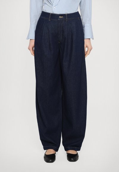 Dunkelblaue, weit geschnittene Denim-Hosen mit hoher Taille. Mit einem Knopfverschluss vorne und dezenten gelben Nähten. Weiche Textur.