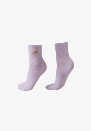 Chaussettes aux chevilles violet clair avec des bords côtelés, présentant un petit visage de chien brodé sur le côté extérieur d'une chaussette.