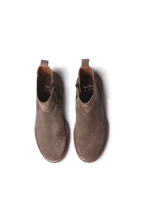 Pruun nahast pahkluu saapad külgsete elastsete paneelidega, õmblemise detailid tallal ja tagaküljel tõmbeauk mugavaks selga panemiseks.