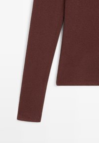 Langärmeliger, dunkelbrauner, gerippter Strickpullover mit geradem Saum vor weißem Hintergrund.