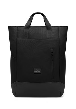 Mustan kankaisen kassi, jossa on kestävä kangas, kaksi yläkahvaa, etupuolella vetoketjullinen tasku ja teksturoitu alaosa. Brändilogo edessä.