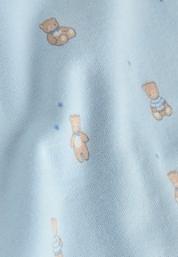 Ljusblått tyg med mjuk textur, med ett upprepat mönster av små teddybjörnar i olika poser och några utspridda stjärnor.