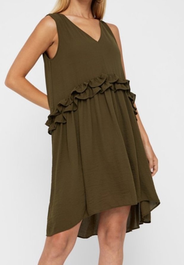 Tummanvihreä hihaton mekko, jossa on V-pääntie. Mekossa on röyhelökoristeet vyötärön ympärillä ja takana hieman pidempi helma. Materiaali on sileä.