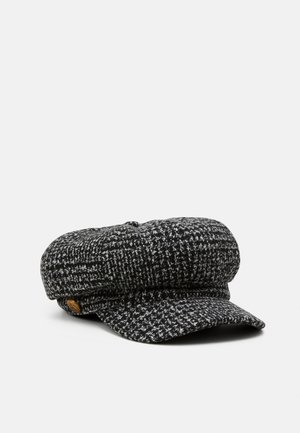 Casquette gavroche en tweed noir et blanc avec une visière courte et un bouton doré décoratif sur le côté.