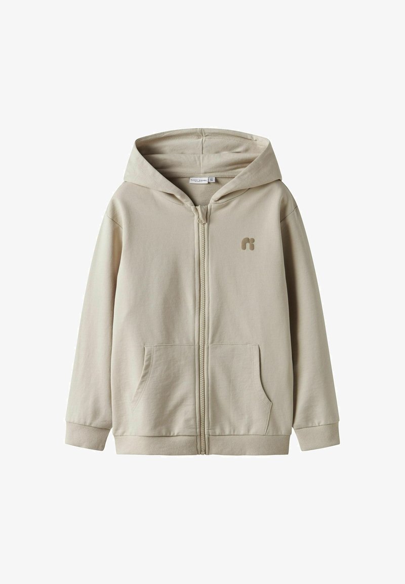Sweat à capuche beige zippé en mélange de coton, avec une poche avant, des poignets côtelés et un logo sur la poitrine. Texture douce et design décontracté.
