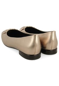 Chaussures plates métalliques dorées avec un bout arrondi, détails de plis subtils à l'avant et une semelle en caoutchouc noir et plate.