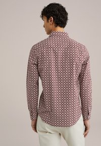 Langarmshirt in mahonie met een wit bloemenpatroon. Heeft een klassieke kraag en een gebogen zoom, gemaakt van een lichtgewicht stof.
