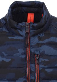 Marinblå kamouflage vadderad jacka med två vertikala röda dragkedjor och hög krage.