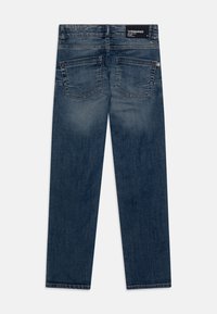 Granatowe dżinsy z prostymi nogawkami, z dwiema tylnymi kieszeniami, widocznymi szwami i etykietą marki na pasku.