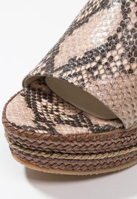 Texturerad plattformssandal i faux ormtryck, med bred öppen t å, flätade detaljer runt basen och en slät innersula.