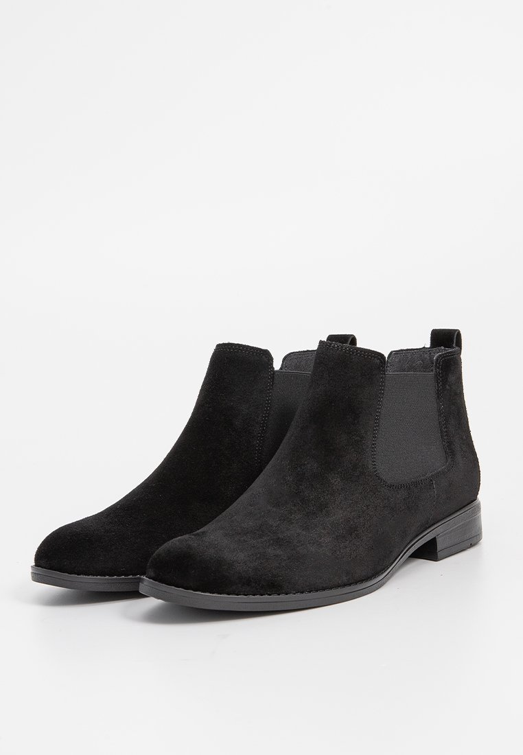 Schwarze Wildleder-Ankle Boots mit elastischen Seitenpaneelen, runder Zehenpartie und flacher Gummisohle. Das Design zeichnet sich durch ein glattes Obermaterial und minimalen Nähten aus.