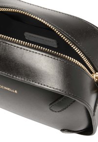 Borsetta in pelle nera con chiusura zipper dorata. All'interno presenta un'etichetta del marchio e una superficie liscia. Design compatto con bordi arrotondati.