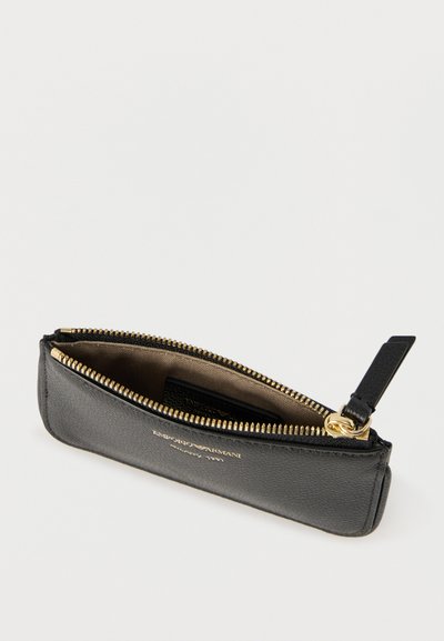 Μαύρο δερμάτινο πουγκί με φερμουάρ σε χρυσό χρώμα και μικρή εσωτερική θήκη, με ανάγλυφο κείμενο "Emporio Armani Milano 1981" σε χρυσό χρώμα.