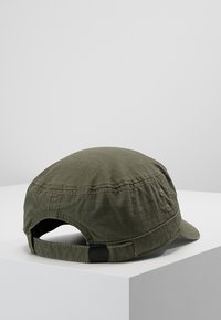 Groene katoenen pet met een ronde vorm, platte rand en verstelbare band achteraan. Heeft zichtbare stiksels en een gestructureerde stof.