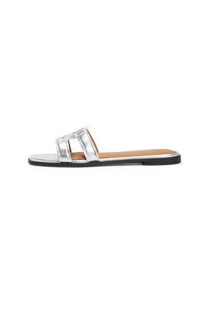 Flad sandal med sølvmetalliske brede dobbelte stropper og en tan polstret fodseng med en sort sål vist fra siden.