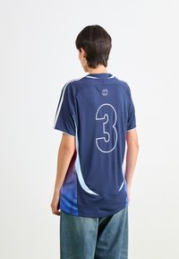 Tamsiai mėlyna sportinė marškinėliai su degradacija, ant nugaros yra baltas skaičius '3', trumpomis rankovėmis, lygia tekstūra ir apykaklė.