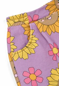 Tessuto a motivo viola con girasoli e fiori rosa. Include una tasca laterale e una vita elasticizzata per il comfort.