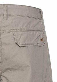 Graue Baumwollshorts mit einer glatten Textur, ausgestattet mit einer Gesäßtasche mit Klappe und gestickten Details sowie einem kleinen Logoakzent in der Nähe der Tasche.