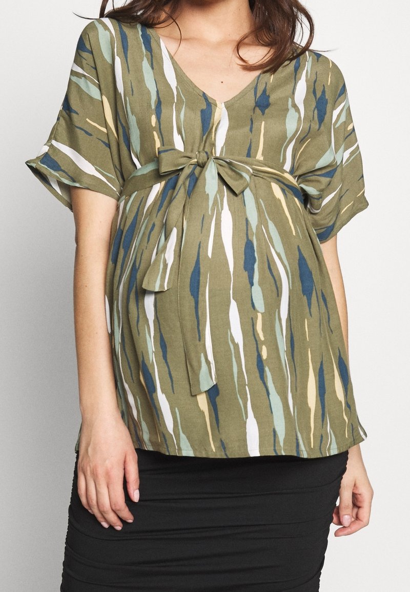 Maternity blouse in olive green, featuring a V-neck, short sleeves, and a tie at the waist with a multicolor abstract pattern.