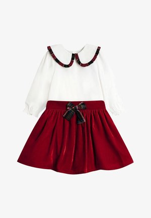 Weißes langärmliges Kleid mit weitem Kragen, der mit kariertem Muster besetzt ist, kombiniert mit einem tiefroten Samtrock und passender karierter Schleife an der Taille.