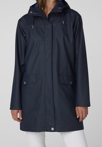 Imperméable de marine avec capuche, doté d'une fermeture éclair frontale, de deux poches latérales et d'un cordon de serrage ajustable. Matériau lisse avec un design élégant.