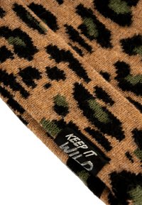 Berretto lavorato a maglia marrone con un motivo leopardato in nero e verde. Include un'etichetta nera con la scritta "KEEP IT WILD" in bianco.