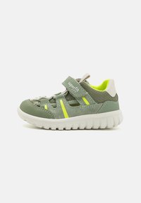 Scarpa verde per bambini realizzata in materiali mesh e suede, con strisce gialle, una cintura in Velcro e una suola in gomma bianca e testurizzata.