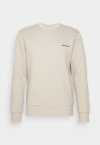 Sudadera beige de mangas largas con puños acanalados, que presenta un pequeño logo negro de "Carhartt" en el lado izquierdo del pecho. Textura de tela suave.