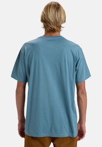 Blå kortærmet t-shirt i et ensartet, blødt stof med en rund halslinje og en afslappet pasform, uden synlige mønstre eller logoer.