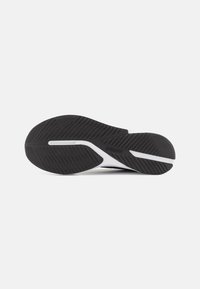 Suola di scarpa atletica nera con superficie in gomma texturizzata, con un midsole bianco e design elegante per grip e flessibilità.