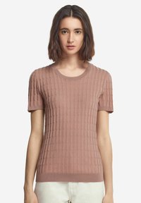 Ljusrosa stickad kortärmad tröja med en texturerad ribbdesign, rund halsringning och figurnära silhuett. Slät textur och subtila accenter.