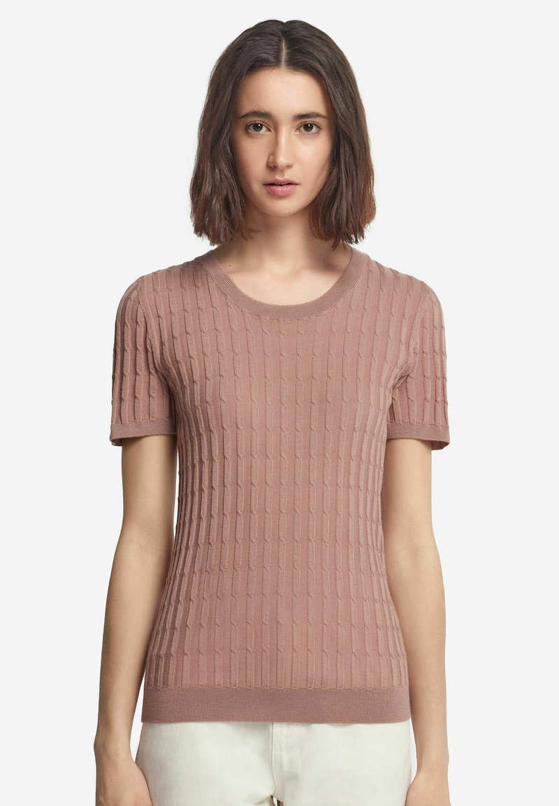 Ljusrosa stickad kortärmad tröja med en texturerad ribbdesign, rund halsringning och figurnära silhuett. Slät textur och subtila accenter.