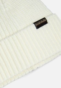 Berretto lavorato a maglia bianco con texture a coste e risvolto. Include un piccolo etichetta nera con il nome del marchio.