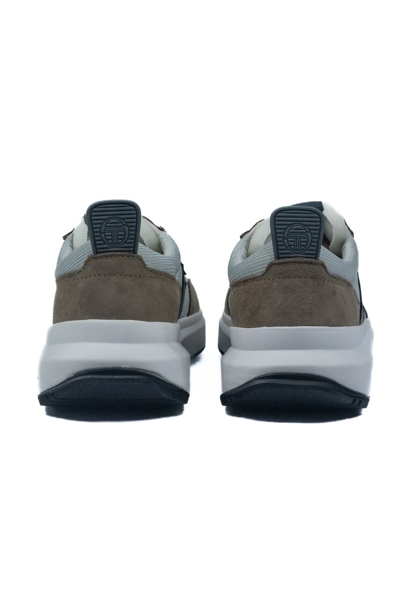 Zapatillas deportivas de ante marrón y malla gris con suelas blancas; cuentan con un respaldo texturizado y detalle del logo en la lengüeta del talón.