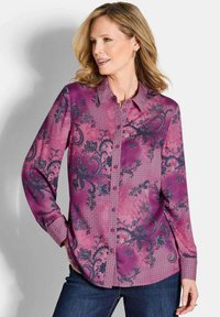 Paarse langslip blouse met bloemen- en geometrische patronen, met een knoopsluiting en subtiele textuuraccenten.