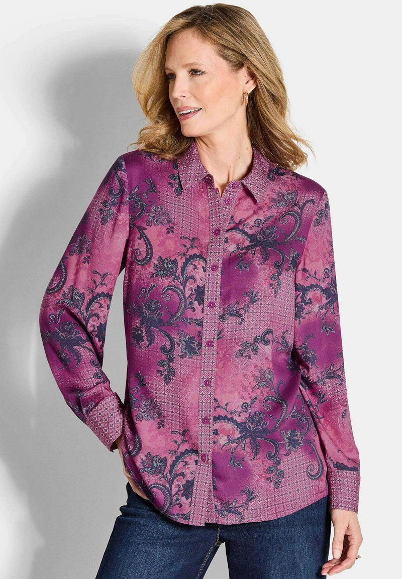 Paarse langslip blouse met bloemen- en geometrische patronen, met een knoopsluiting en subtiele textuuraccenten.