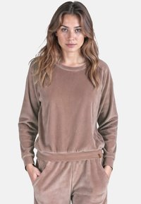 Felpa in velour marrone con maniche lunghe, collo rotondo e vita aderente. Tessuto morbido e design rilassato, ideale per un look casual.