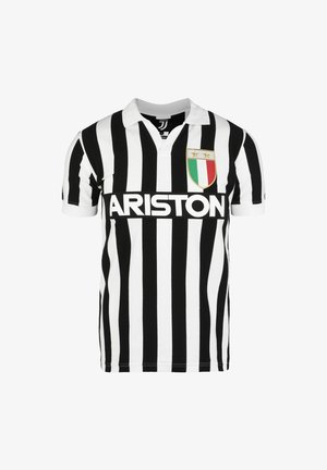 Maglietta a righe bianche e nere con colletto polo. Presenta il logo "ARISTON" e un distintivo con accenti verdi, bianchi e rossi.